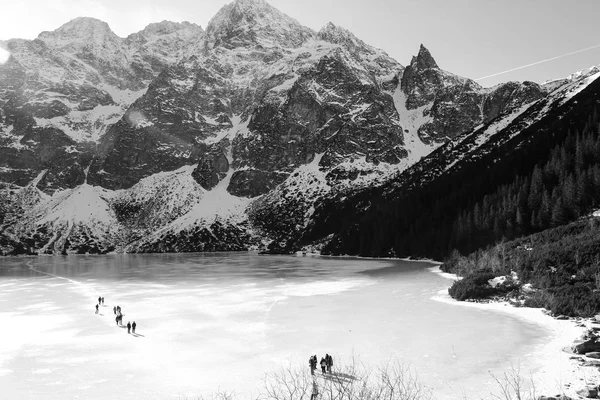 Panorama blanco y negro de lago congelado rodeado de montañas . — Foto de Stock