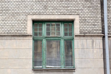 Evin bir drenaj p ile gri bir cephesinde yeşil ahşap pencere