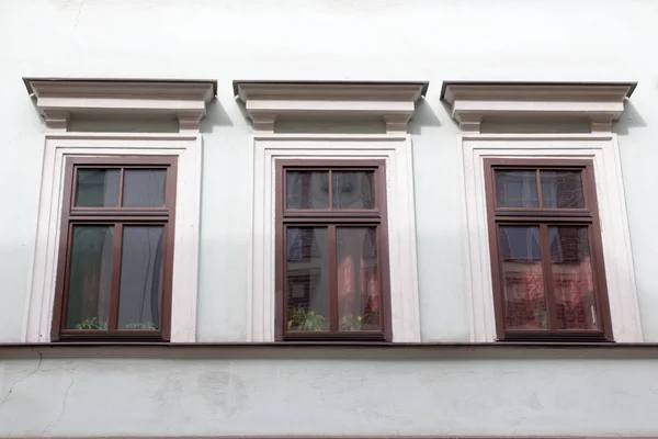 Three wooden windows on the facade of the white house — Stock Photo, Image