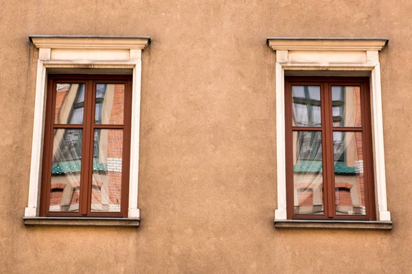 Dos ventanas rojas de diseño vintage en la fachada de la antigua casa — Foto de Stock