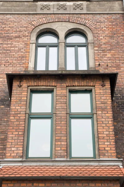 Ventanas de diseño vintage con un balcón en la fachada de ladrillo de th —  Fotos de Stock