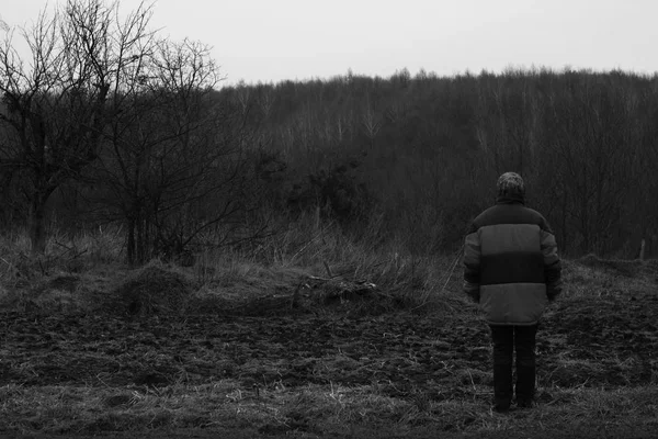 Bir kadın geri döndü ve karanlık ormana bakıyor