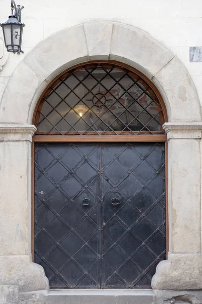 Винтажная черная металлическая входная дверь со старым фонариком — стоковое фото