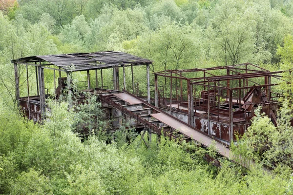 Construcción industrial oxidada de hierro viejo en el medio del frente — Foto de Stock