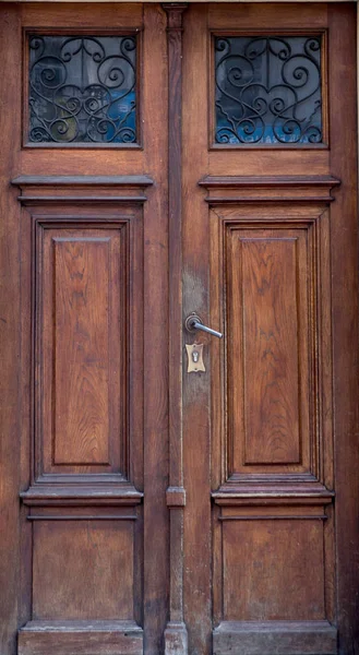 Stara vintage drewniane brązowe drzwi z bliska z wstawki i handlowej patte — Zdjęcie stockowe