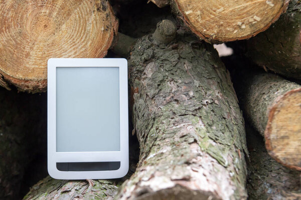 Электронная книга на фоне поваленных деревьев, спаси деревья - читай эбу
