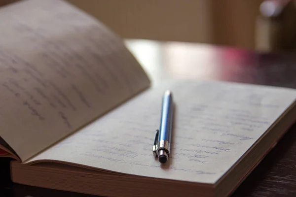 Bloc-notes ouvert avec notes manuscrites avec stylo bleu — Photo