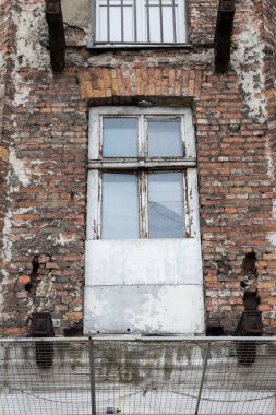 Eski tuğla duvarın cephesinde dağınık pencere