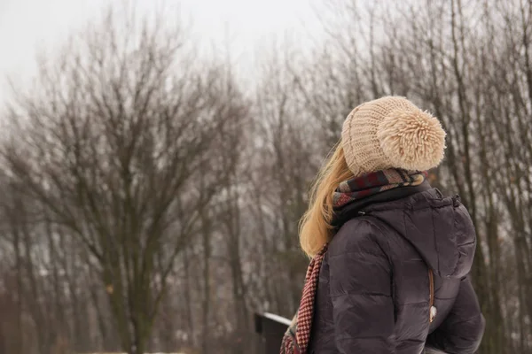 girl stands with his back turned and looking at the winter fores