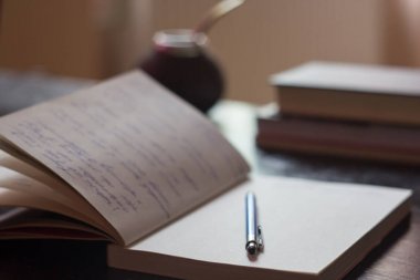 Açık Not Defteri ile mavi kalem, kitap ve mate ile el yazısı metin