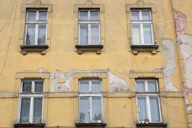 Eski püskü sarı ev cephesinde altı Windows