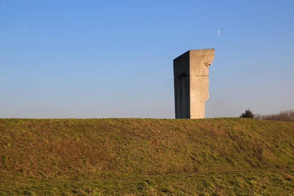 Das Betondenkmal auf dem Hintergrund von grünem Gras und Himmel — Stockfoto