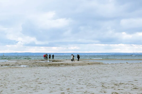 İnsanlar kum deniz kıyısında yürüyüş