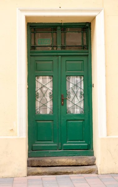 A porta dianteira de madeira marrom do projeto verde do vintage de um hous velho — Fotografia de Stock