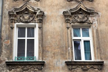 Eski yırtık pırtık tuğla bina cephesinde iki pencere