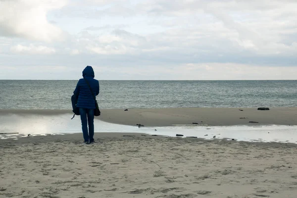 Yalnız bir kız boş bir sahilde duran ve s arıyor