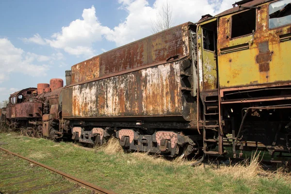 Velhas locomotivas enferrujadas e carros — Fotografia de Stock