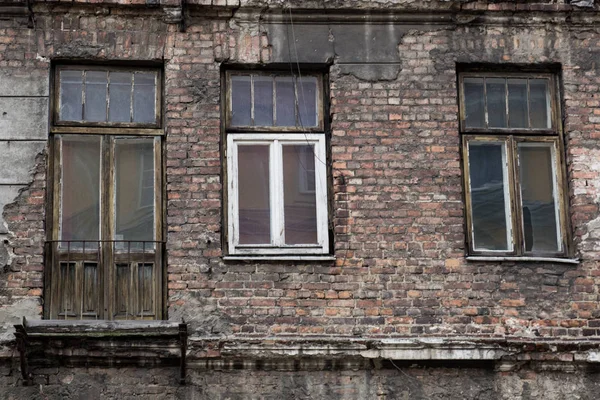 Фасад старого заброшенного дома с окнами и дверью — стоковое фото