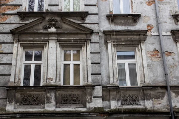 Three Vintage design windows on the facade of the ragged old hou — Stock Photo, Image