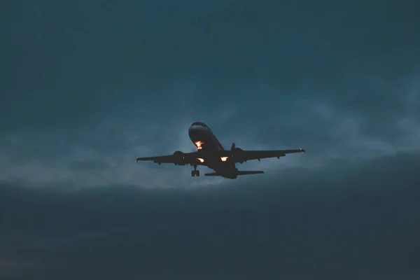 Passagierflugzeug hebt in der Abenddämmerung ab, bald Nacht — Stockfoto