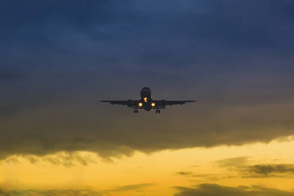 O avião descola no fundo do pôr-do-sol e voa em dus — Fotografia de Stock