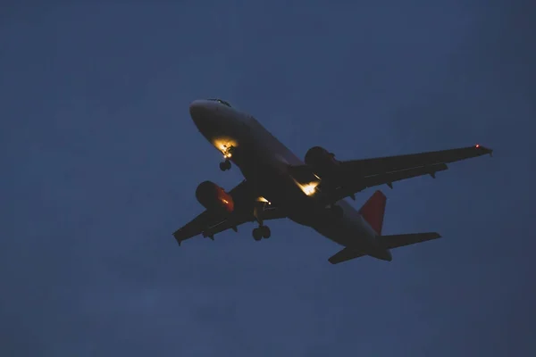 Passageiro ou avião de carga voa para o céu escuro ao anoitecer no ev — Fotografia de Stock