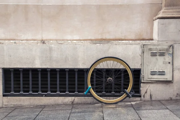 Koło roweru przykuty przez dwa zamki do elewacji — Zdjęcie stockowe