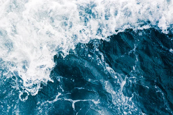La superficie del mar con olas, salpicaduras, espuma y burbujas, un —  Fotos de Stock