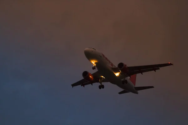Um avião decolando no fundo do céu vermelho amarelo e azul — Fotografia de Stock