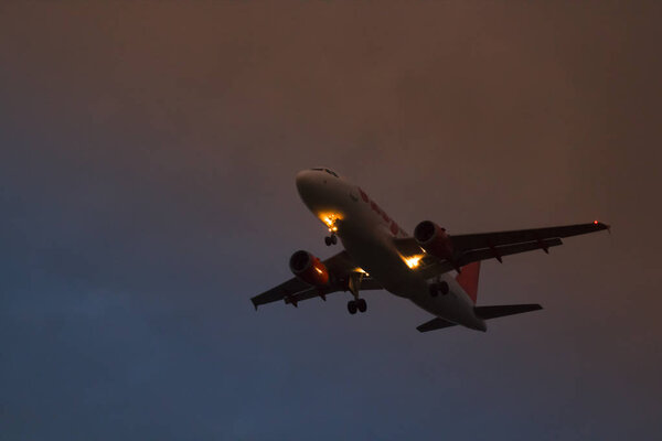 A plane taking off on the background of red yellow and blue sky