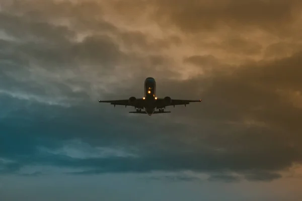 Un avión despegando en el fondo del cielo dramático y la puesta del sol — Foto de Stock