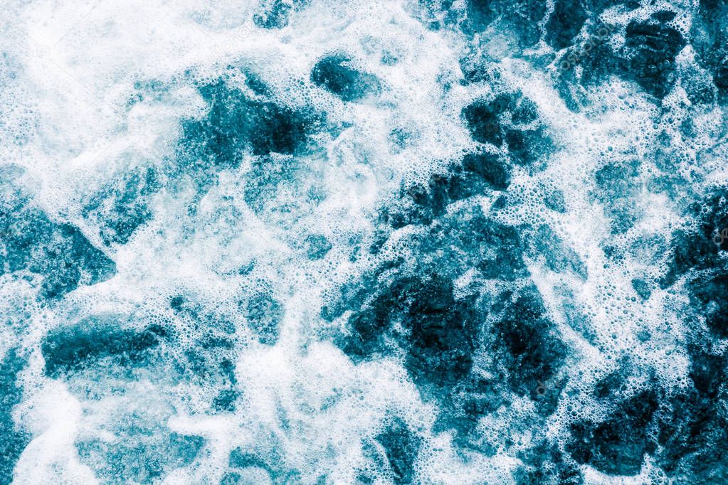 The blue surface of the water with white foam and gurgling, abst