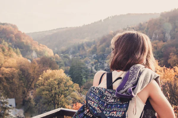 Молода красива брюнетка дівчина з рюкзаком дивиться на осінь мо — стокове фото