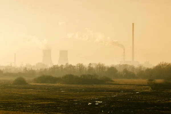 Paisaje natural con fábrica y tuberías de las cuales va humo en t — Foto de Stock