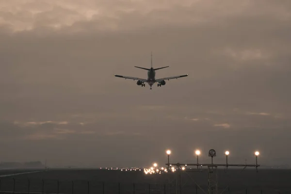 Пассажирский самолет приземляется на фоне сумерек , — стоковое фото