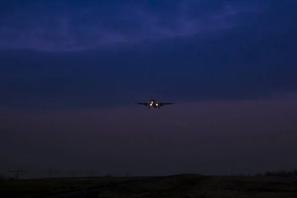 El avión de pasajeros va a aterrizar sobre un fondo de twil —  Fotos de Stock