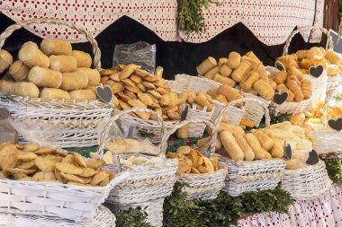 Beyaz sepetler içinde farklı füme ev yapımı peynir bir sürü yatıyor 