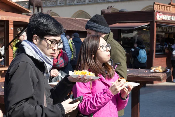 KRAKOW, POLONIA, 2 de abril de 2018, Joven asiático y chica comiendo s — Foto de Stock