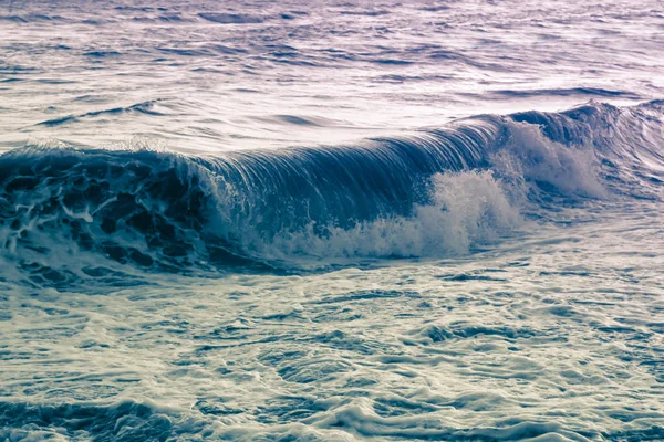 Blauviolett wirbelnde Meereswelle überflutet die Küste, eine surreale Meereslandschaft — Stockfoto