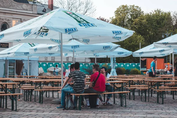 KRAKOW, POLONIA, 21 de abril de 2018, Mucha gente se sienta en el portab de madera — Foto de Stock