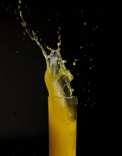 Siyah arka plan üzerine izole sıçrama ile portakal suyu bir bardak — Stok fotoğraf