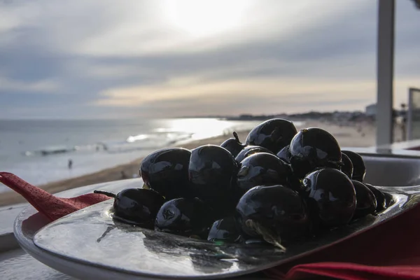 Olijven schotel met uitzicht op het strand — Stockfoto