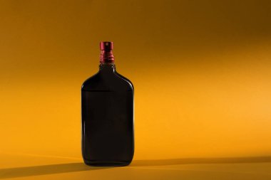 İzole Sarı zemin üzerine siyah adam parfüm şişesi