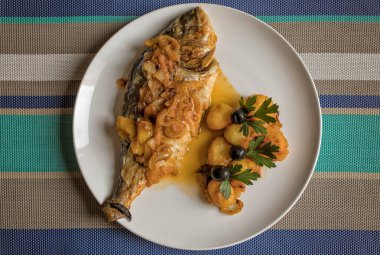 Balık pişmiş fırında, haşlanmış patates ve zeytin ile altın