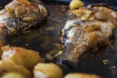 Balık pişmiş fırında, haşlanmış patates ve zeytin ile altın