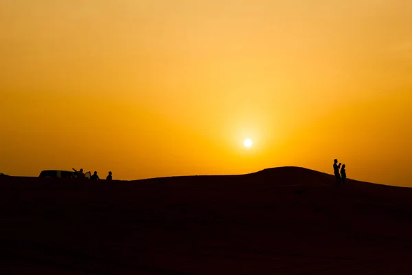 Силуэт людей в пустыне Дубай, с закатом . — стоковое фото