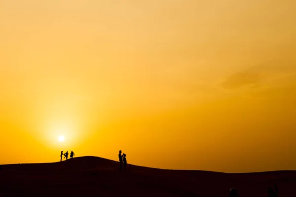 Силуэт людей в пустыне Дубай, с закатом . — стоковое фото