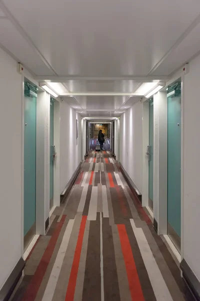 Chica caminando en el pasillo del hotel con la maleta . —  Fotos de Stock