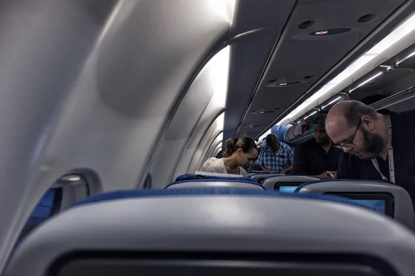 Inside view of airplane with people packing their bags. — Stock Photo, Image