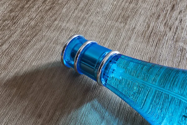 Feminino, perfume azul isolado em fundo de madeira — Fotografia de Stock